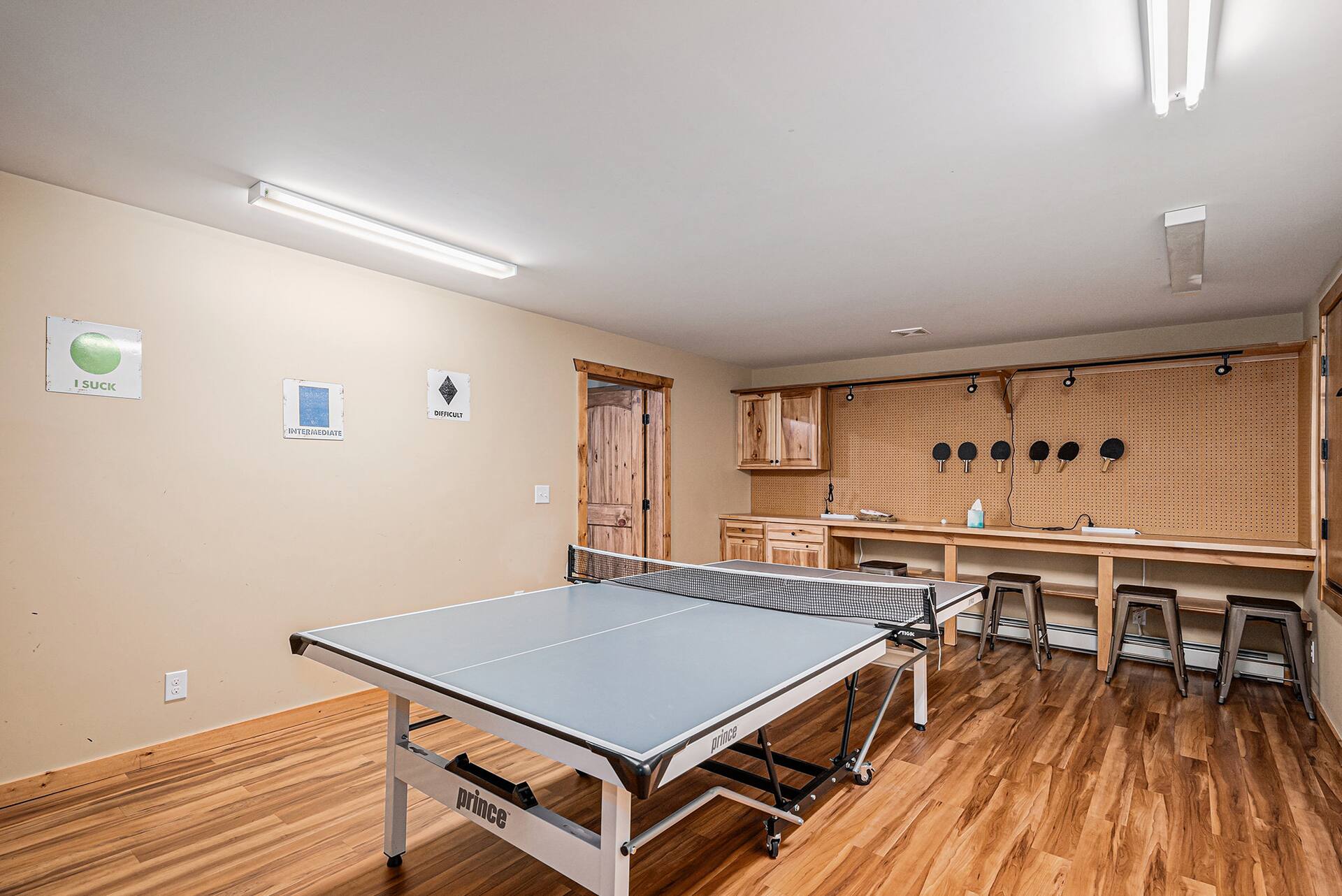 Ping pong room with a wall of paddles and counter seating