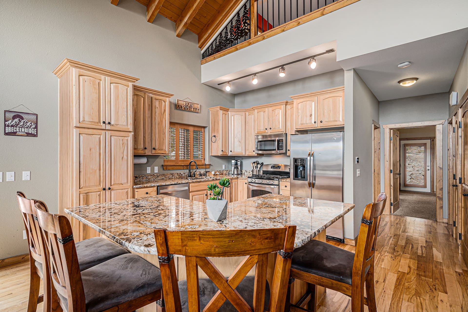 Kitchen with a granite island, honey-toned custom cabinets and stainless appliances